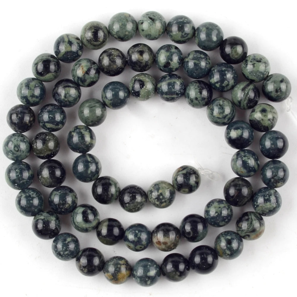 A strand of dark green and black jasper and turquoise beads for jewelry making