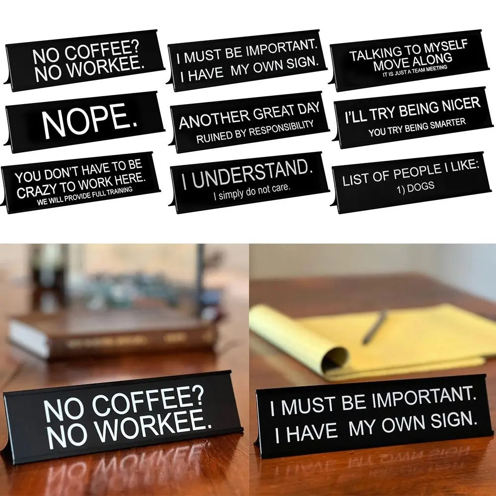 A collection of black desk signs with humorous phrases like NO COFFEE NO WORKEE and I MUST BE IMPORTANT.