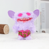 A purple fuzzy monster plush toy with pink eyes and a leopard print belly, sitting on white fabric.