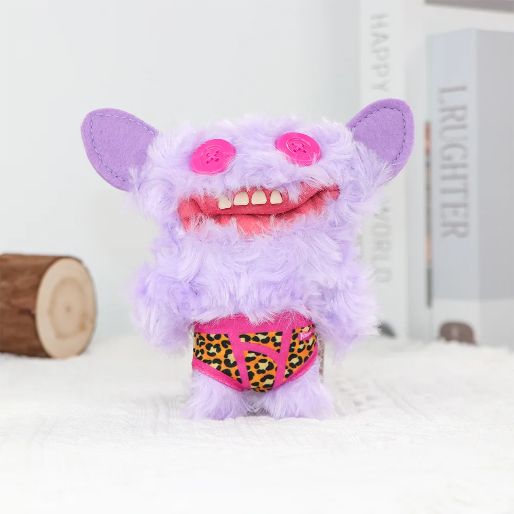 A purple fuzzy monster plush toy with pink eyes and a leopard print belly, sitting on white fabric.