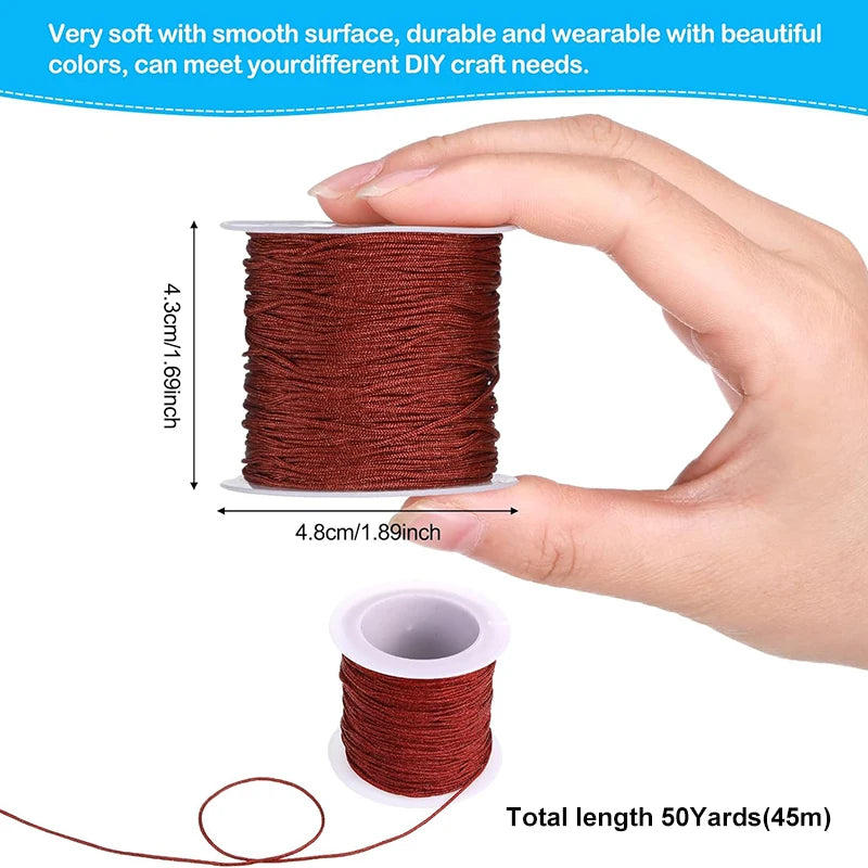 A hand holds a spool of reddish-brown nylon knotting cord for jewelry making, showing its size and texture.