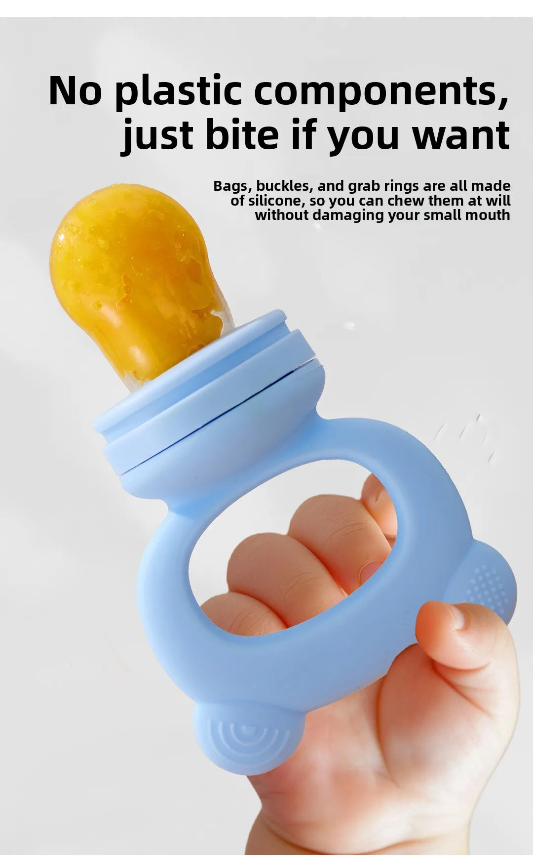 A hand holds a light blue silicone fruit teether, with a yellow piece of fruit attached.