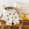 Cream casual pants for kids with a plaid print featuring small brown animal motifs and elastic waist