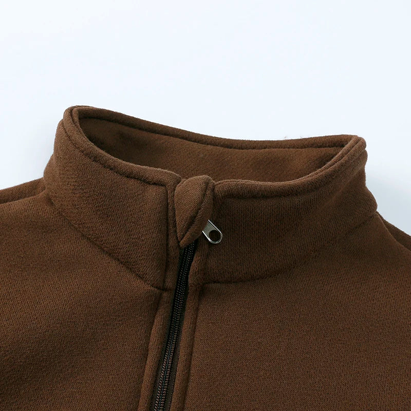 Close-up of a brown fleece hooded tracksuit jacket with a zipper and ribbed collar.