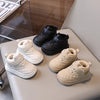 A collection of toddler winter snow boots in black and beige leather, displayed on a light surface.