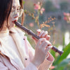 A young woman holds an 8-hole soprano recorder for kids and beginners outdoors.
