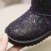 A close-up of a purple glitter snow boot being held, showing the textured fabric and black sole.