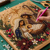 A hand is painting a detailed Christmas scene featuring Jesus and Mary with pearls and gold accents on a canvas.