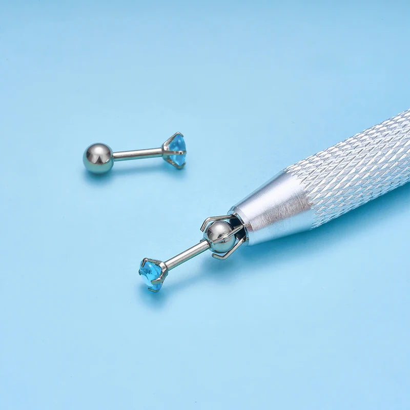 A silver precision bead and jewelry pick-up tool with a textured handle and a blue gemstone tip.