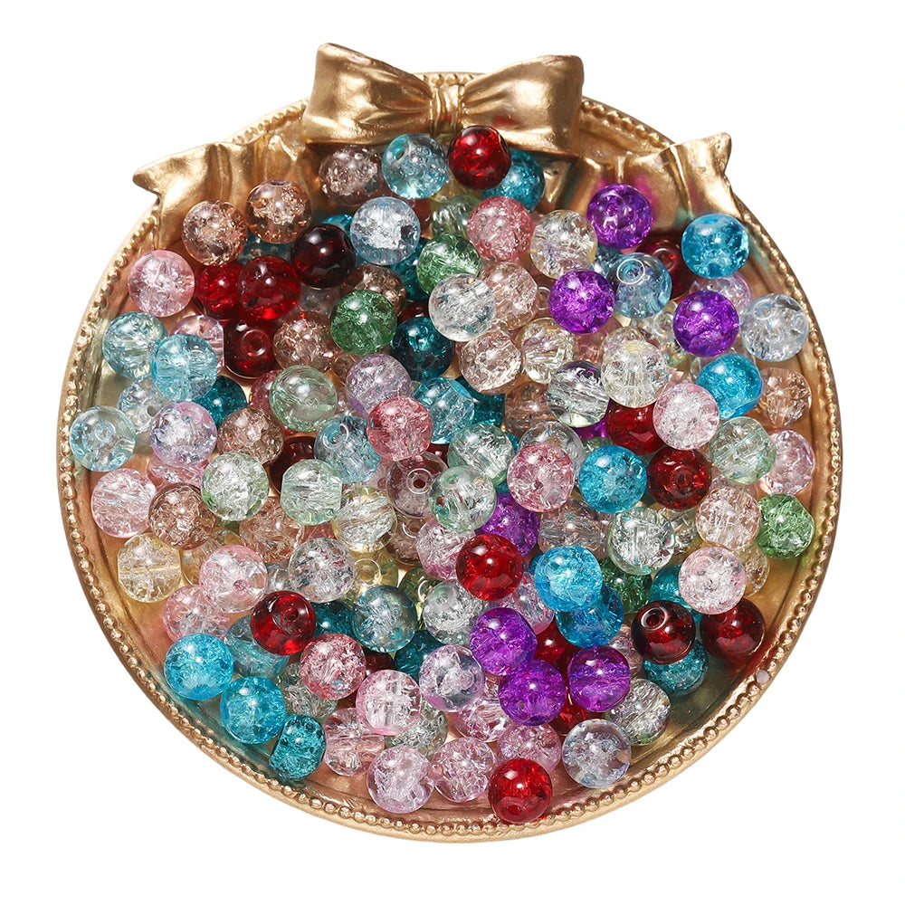 A collection of colorful 8mm glass crackle beads in various shades and sizes displayed in a gold-toned dish.
