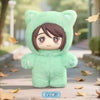 A soft mint green plush toy shaped like a cat head with brown hair, displayed outdoors on a paved path.