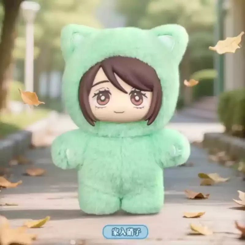 A soft mint green plush toy shaped like a cat head with brown hair, displayed outdoors on a paved path.