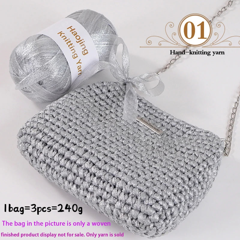 A gray knitted bag made from a silver yarn is shown next to a ball of silver knitting yarn.