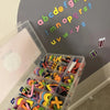 A clear plastic storage box filled with a colorful magnetic letter set for educational learning.