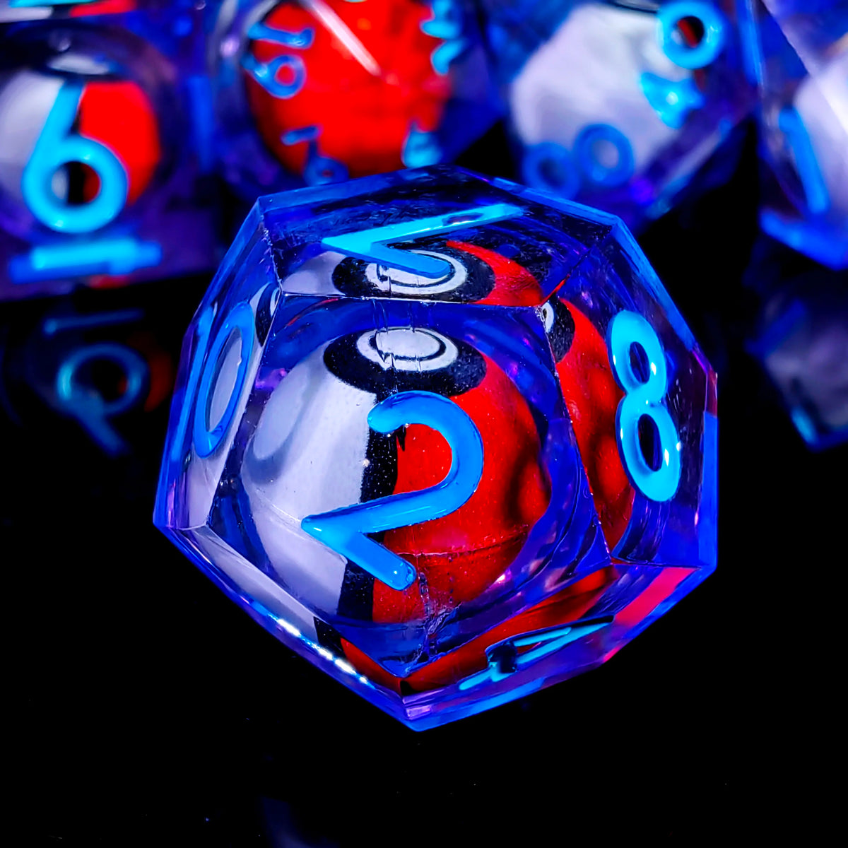 Nahaufnahme eines durchsichtigen blauen Polyederspielwürfels mit roten und weißen Markierungen vor dunklem Hintergrund