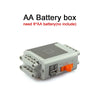 A gray AA battery box with connectors and a small orange component.