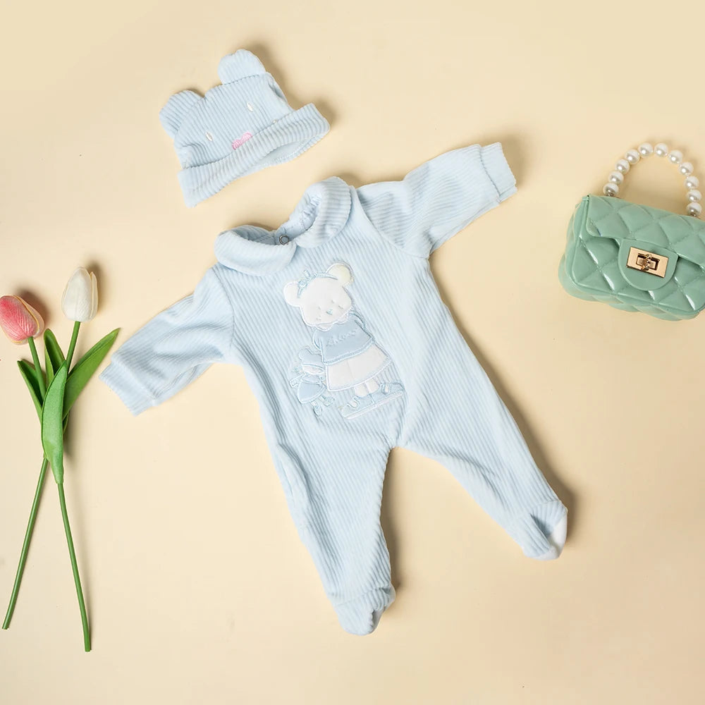 Light blue striped romper set for a baby doll includes a matching hat and a green handbag