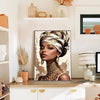 A close-up portrait of a woman with intricate gold jewelry and a patterned head wrap, displayed in a framed print.