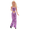 A fashion doll wearing a purple sequin party trousers set with gold jewelry.