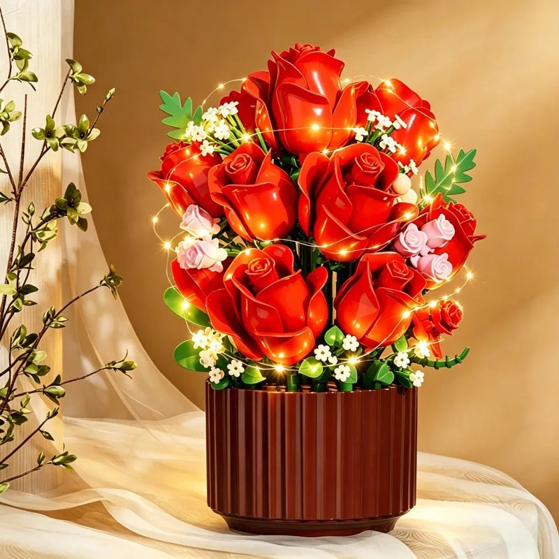 A vibrant bouquet of red roses and white filler flowers displayed in a pot with warm string lights.