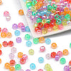 A pile of colorful pony beads in various shades including pink, green, yellow, and blue.