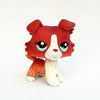 A small, sculpted pet figurine resembling a red and white dog face with large blue eyes.
