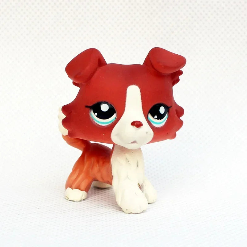 A small, sculpted pet figurine resembling a red and white dog face with large blue eyes.