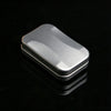 A silver metal fidget slider with a magnetic core resting on a reflective black surface.