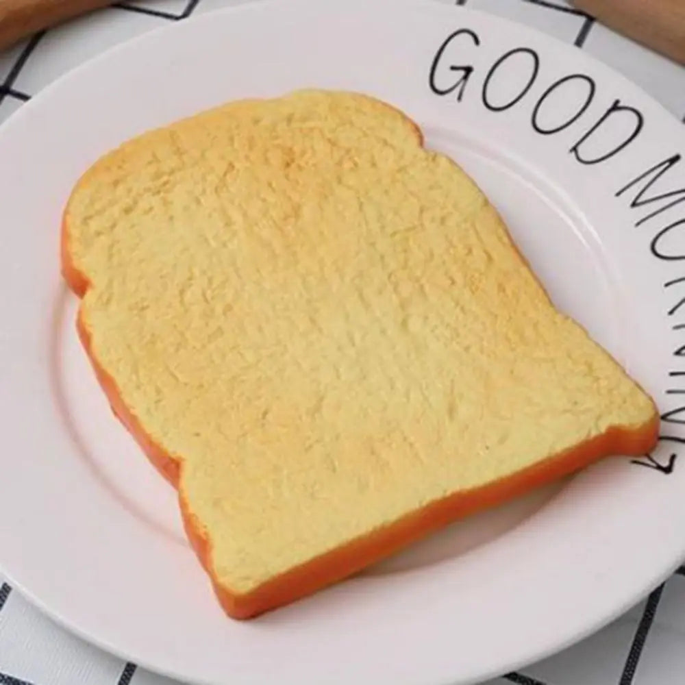 A slice of bread is placed on a white plate with text that reads GOOD MORNING.