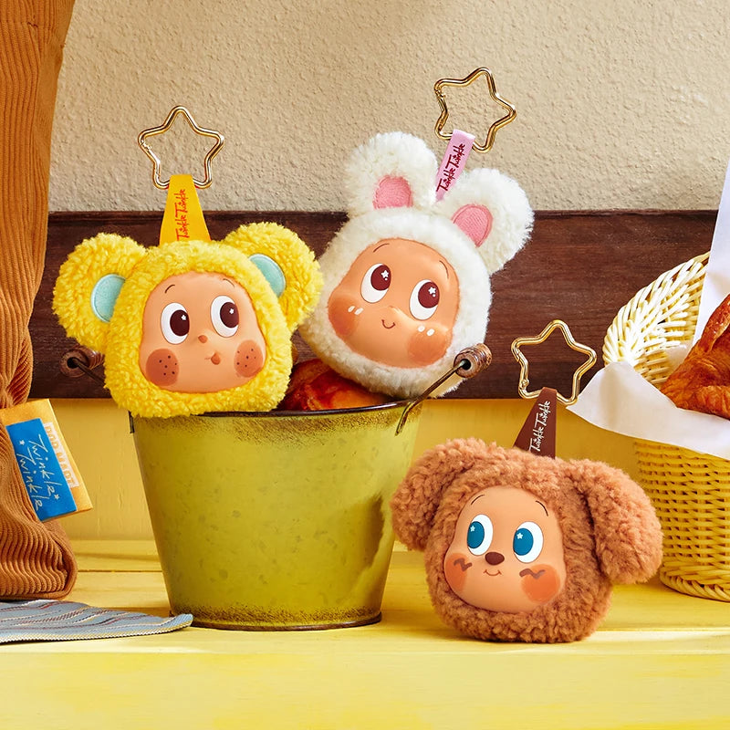 Two plush animal-themed earbud case covers, one yellow and one white, displayed in a green cup.