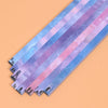 A collection of 27 narrow, iridescent paper strips in various pastel colors and glitter patterns for crafting.
