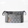 A gray fabric organizer bag for strollers featuring a zippered pocket with a white tree pattern.