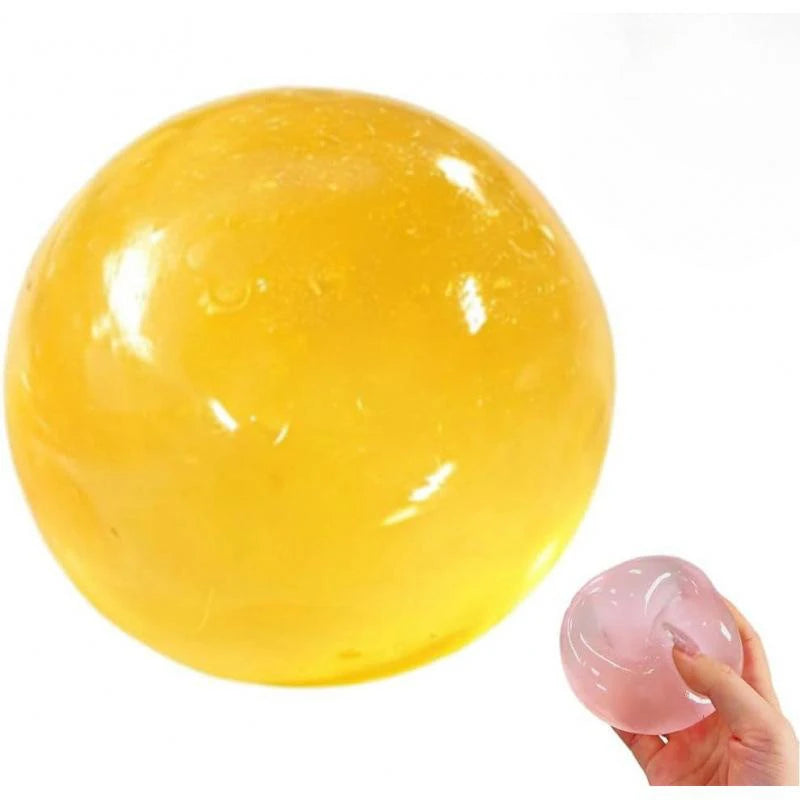 A large, translucent yellow coconut oil squishy stress ball is shown against a white background.