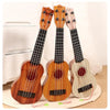 Three wooden toy guitars, including a ukulele-style instrument, are displayed on a light surface.