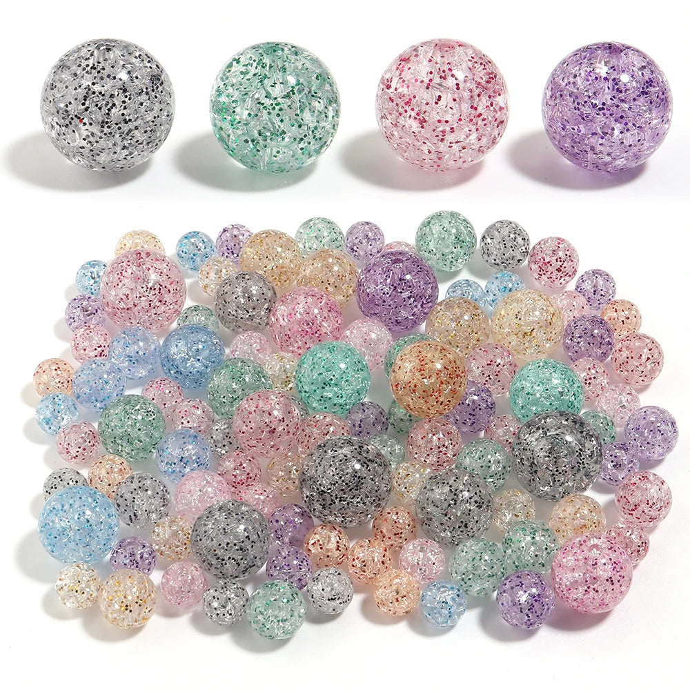 A collection of round loose glitter cracked acrylic beads in various colors including pink, purple, green, and silver.
