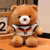 A fluffy brown teddy bear wearing a white and black football jersey with the number 11.