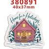 A die-cut sticker featuring a rustic wooden house with festive decorations and evergreen trees.