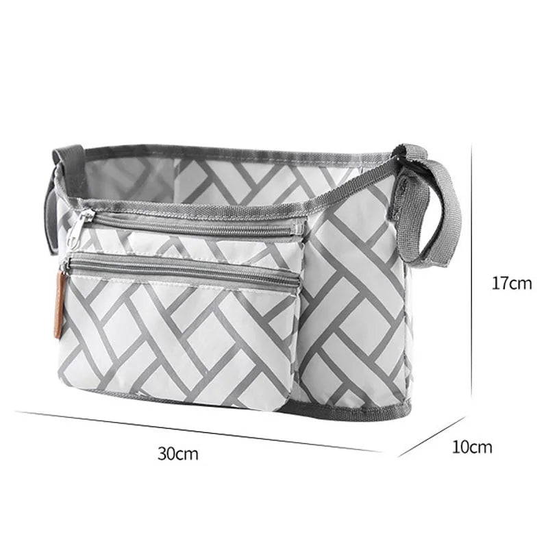 A gray and white patterned fabric organizer bag designed for strollers, featuring a zippered compartment and hanging hooks.