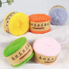 A collection of brightly colored mohair blended yarn skeins in yellow, orange, blue, and pink are displayed on a white surfac