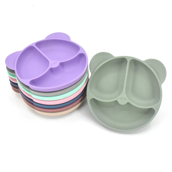 Une pile de neuf assiettes de tétées en silicone violet et une assiette verte individuelle.