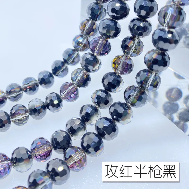 A close-up of a strand of dark gray and purple Austrian crystal beads with an AB coating.