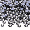 A close-up view of various clear and purple glass crystal rhinestones scattered on a white background.