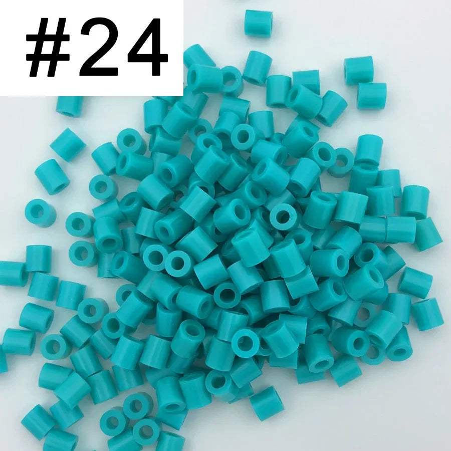 A pile of 1000 small, cylindrical fuse beads in various shades of teal and blue.