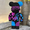 A large, colorful building block display model of a bear with black and neon pink and blue patterned clothing.