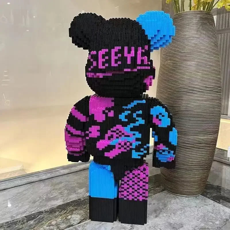 A large, colorful building block display model of a bear with black and neon pink and blue patterned clothing.