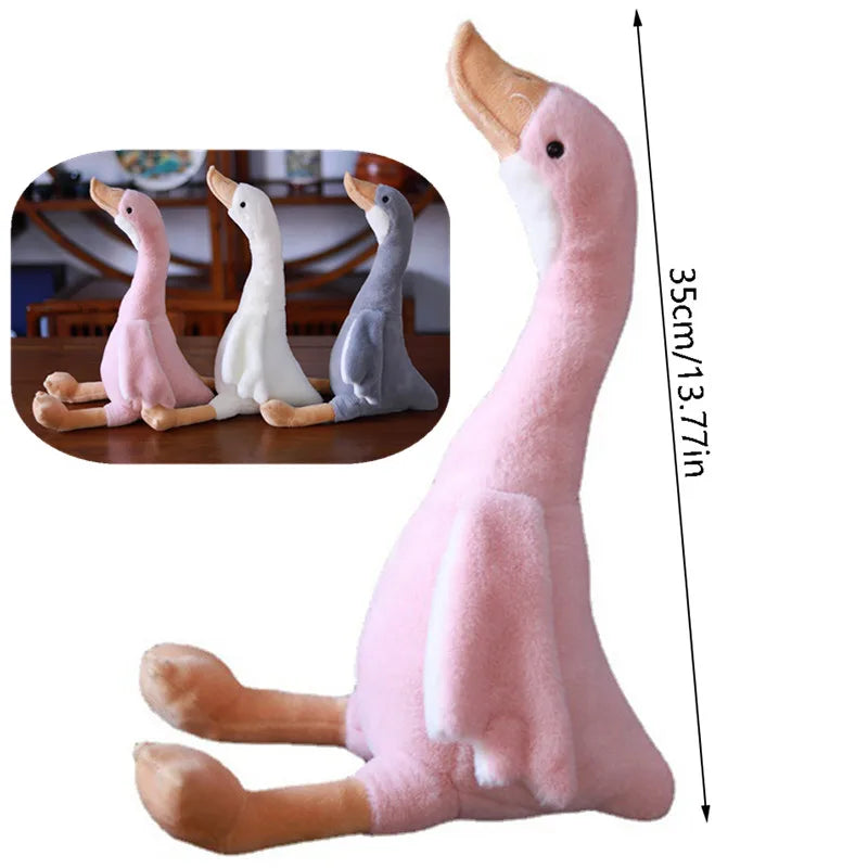 A pink long neck goose plush doll standing upright with a measurement scale showing its height.