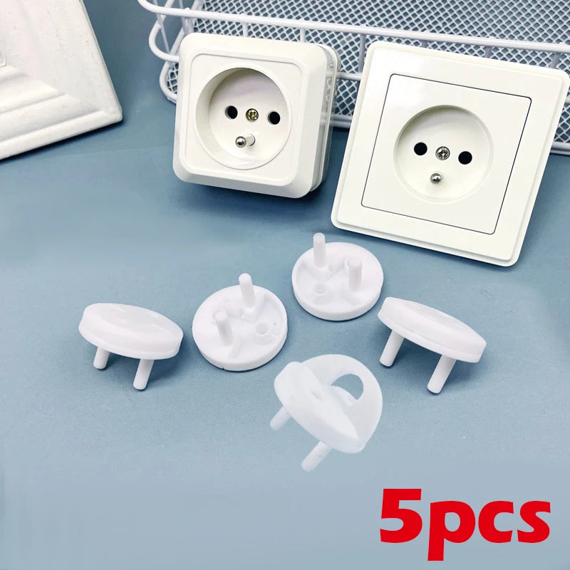 Five white rotating socket safety covers for baby proofing displayed on a light blue surface.