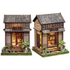 A detailed 3D wooden book nook kit featuring a traditional Japanese-style building with LED lighting and miniature landscapin