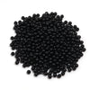 A pile of small, round, black imitation pearl beads for jewelry making.
