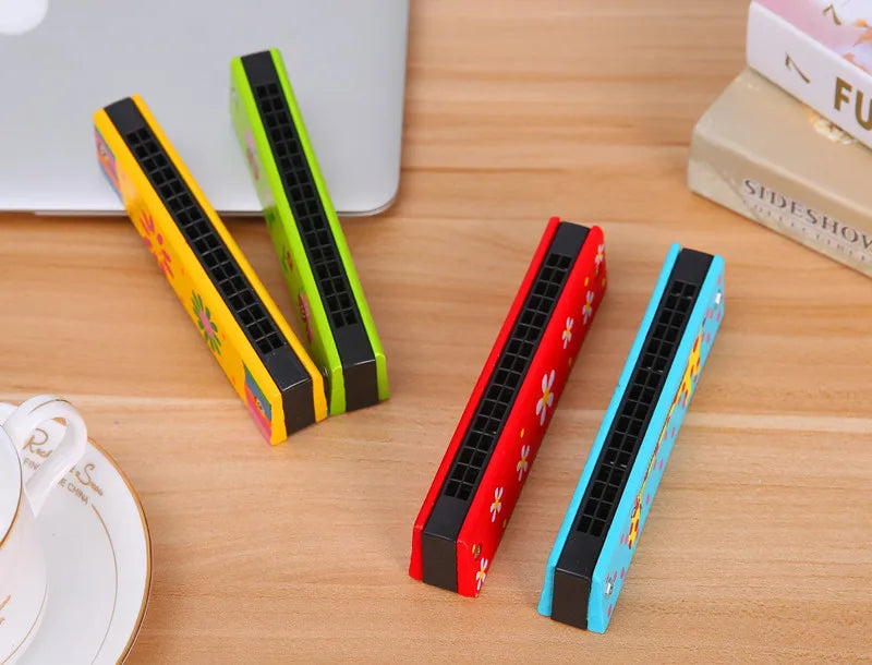 A collection of colorful wooden harmonica products featuring cartoon animal designs on a light wooden surface.